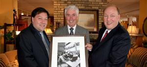 Jory Sherman, left, and Darryl Sherman, right, accept a framed print from UOIT President Dr. Ronald Bordessa.