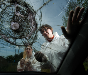 UOIT Applied Bioscience graduate student Katherine Bygarski (right) examines damaged windshield for forensic evidence with Dr. Helene LeBlanc, assistant professor, Forensic Science, UOIT Faculty of Science.