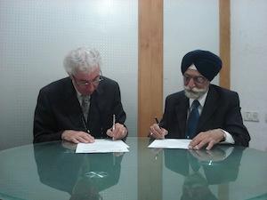Dr. Ronald Bordessa, president, UOIT, signs Memorandum of Understanding with Brig. R.S. Grewal, vice-chancellor, Chitkara University in India.