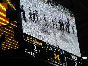 Scoreboard tells the story: UOIT defeats Michigan Wolverines 3-2 in Ann Arbor, Michigan.  Bottom right: 111,000 Michigan football fans see message promoting UOIT-Michigan hockey game during the Wolverines’ football game against Minnesota.  