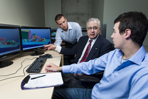 Dr. Moustafa El-Gindy (centre) consults with UOIT Automotive Engineering master's degree students Todd Macdonald (left) and Patrick Galipeau-belair (right).