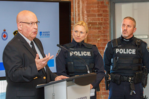 Demonstration of critical incident simulation video. From left: Insp. Bruce Townley, Durham Regional Police Service (DRPS); Det.Cst. Kerry Thompson, DRPS; Cst. Dave Hookway, DRPS. Top image from left: Karim Mamdani, President and CEO, Ontario Shores Centre for Mental Health Sciences; Constable Dave Hookway, DRPS; Susan McGovern, Vice-President, External Relations and Advancement, UOIT; The Honourable Mario Sergio, Minister Responsible for Seniors; Dr. Wendy Stanyon, Associate Professor, Faculty of Health Sciences, UOIT; Sergeant Robin Sanders, Ontario Provincial Police.