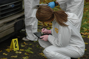A third-year UOIT Forensic Science student documenting a mock hit-and-run crime scene.