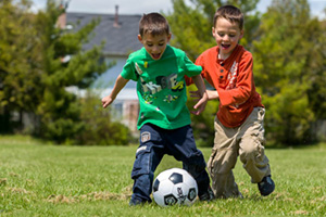 Children with ASD playing soccer outside