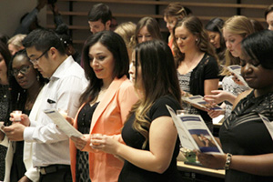 During the candle-lighting, each graduate receives the Bachelor of Science in Nursing pin and recites the Nightingale Pledge.