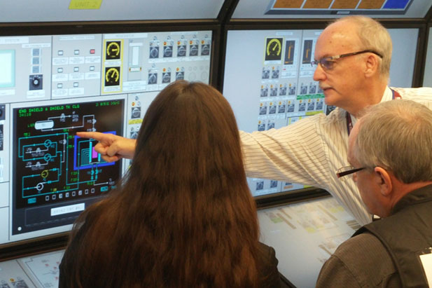 John Shaw, who teaches in the UOIT Faculty of Energy Systems and Nuclear Science's Advanced Operations Overview for Managers program, provides instruction in    the university's Nuclear Simulation Laboratory.