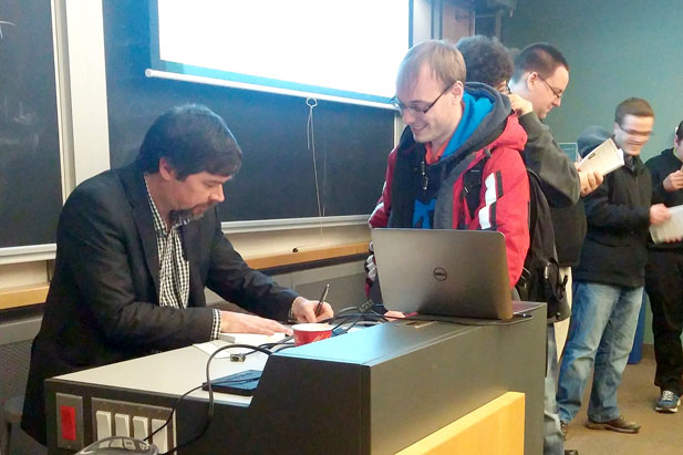 Cybersecurity expert David Millier signs his book, Breached!, at a recent event hosted by the UOIT Networking and IT Security Students’ Society.