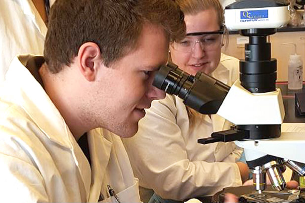 Forensic Science students looking through a microscope