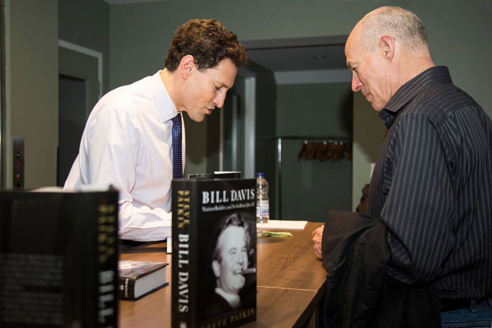 Steve Paikin signs copes of his new book in the lobby of the Regent Theatre.