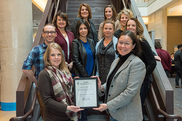 Jen Sullivan of the Region of Durham's Health Department (front left) presents the Region's Healthy Workplace Award to Dr. Deborah Saucier, Vice-President, Academic (front right). They were joined for the presentation by members of the university's Healthy Workplace Committee.