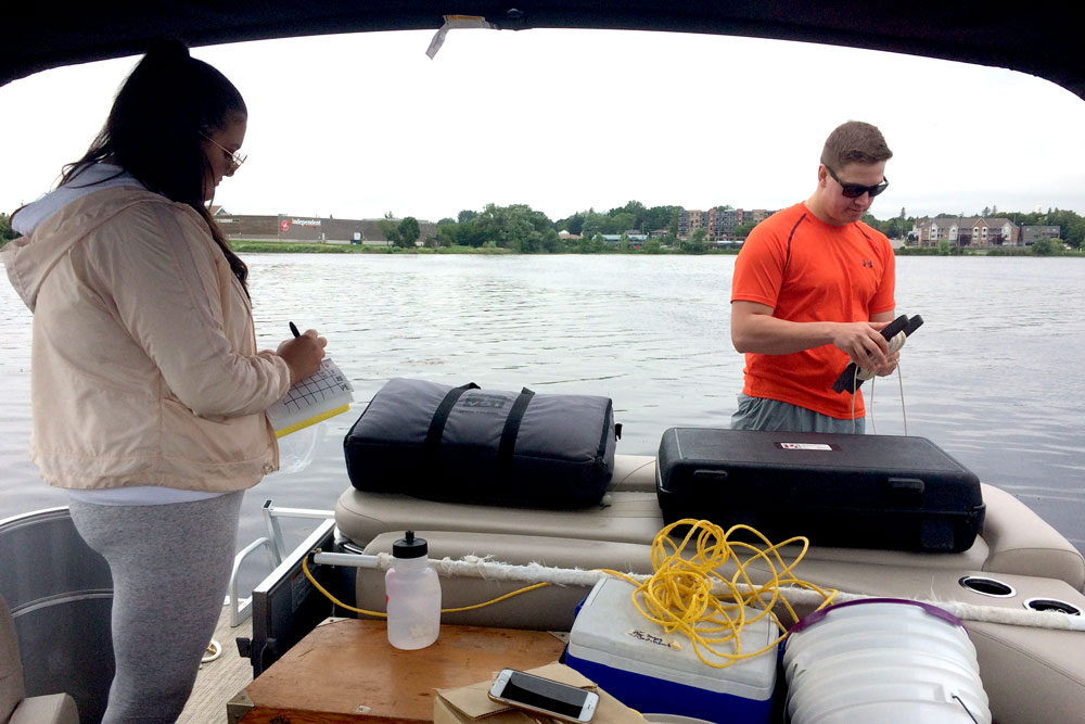 Research team checks the water of Lake Scugog for the invasive species Starry Stonewort (summer 2017).