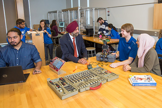 Tarlochan Sidhu, PhD, Dean, Faculty of Engineering and Applied Science (centre) meets with students in a laboratory.
