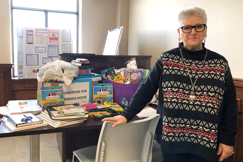 Jaki Mackinnon, Executive Director, Bethesda House, with art supply donations collected for the organization's art therapy program. 