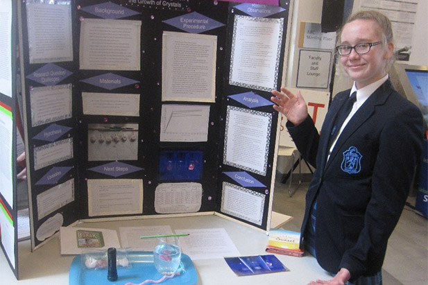 Jordan McKellar with her Durham Regional Science Fair project, Light It Up! The Effect of UV Light on the Growth of Crystals.