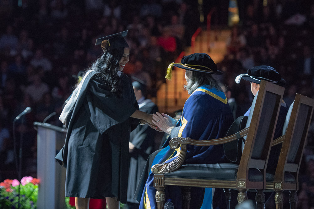 Graduate accepting congratulations from President Steven Murphy and Chancellor Noreen Taylor