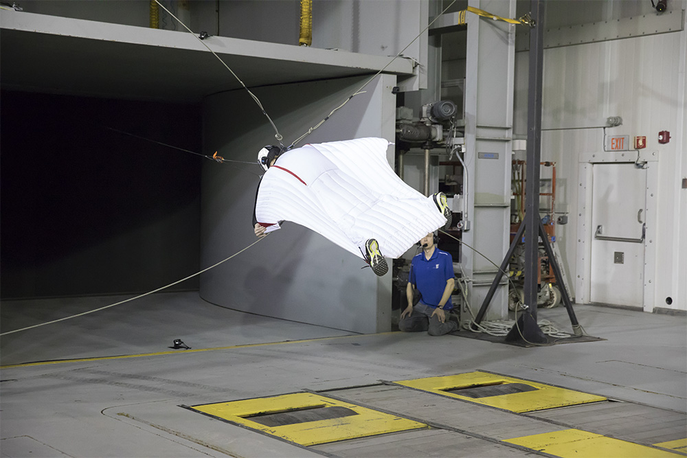 Facing the nozzle of the ACE Climatic Wind Tunnel, British aerospace engineer Dr. Angelo Grubisic tests the capabilities of his wingsuit design in preparation for a world-record altitude jump (12 kilometres) and longest-ever flight in a wingsuit.