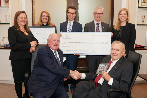 Ron Joyce (seated, right) presents $1 million cheque on behalf of the Joyce Foundation to the University of Ontario Institute of Technology (January 28, 2016).
