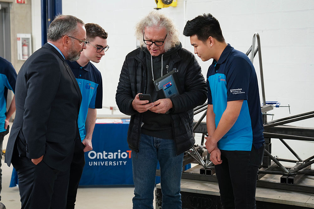 Larry Holt, Chief Technical Officer, Multimatic Inc. (centre) and Dr. Steven Murphy, President and Vice-Chancellor, Ontario Tech University (left) meet with members of the Ontario Tech Racing team.