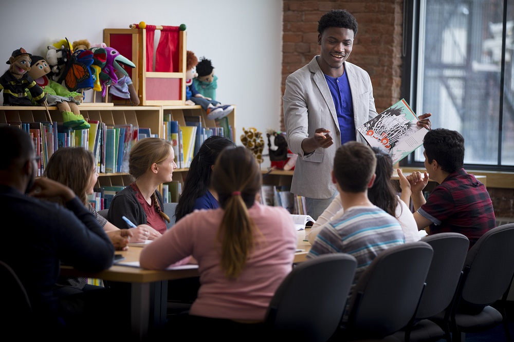 A teacher engages a class with a book