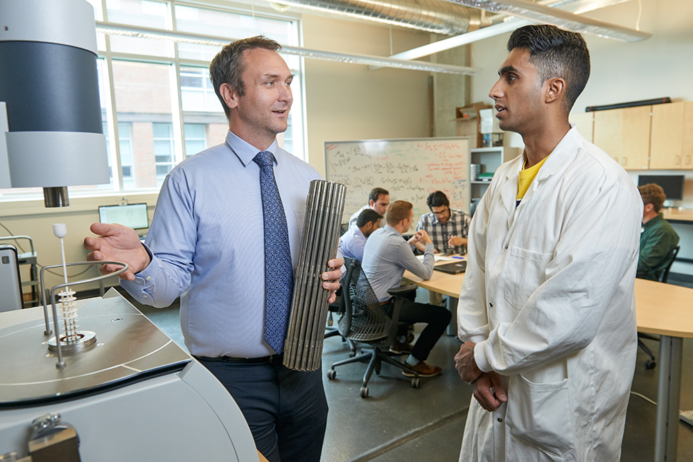 Dr. Markus Piro, Canada Research Chair in Nuclear Fuels and Materials Laboratory at Ontario Tech University (left) speaking with Umer Shahid, Nuclear Engineering graduate (a Research Assistant during his time at Ontario Tech, and now employed with Canadian Nuclear Laboratories).