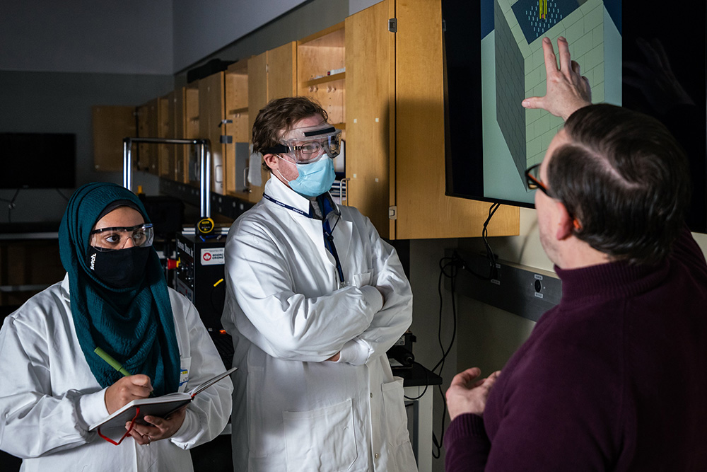 Dr. Kirk Atkinson, Associate Professor, Faculty of Engineering and Applied Science (right) speaks with Nuclear Engineering students about subcritical assembly design concepts, in the Nuclear Facility Complex at Ontario Tech University’s Energy Research Centre.  