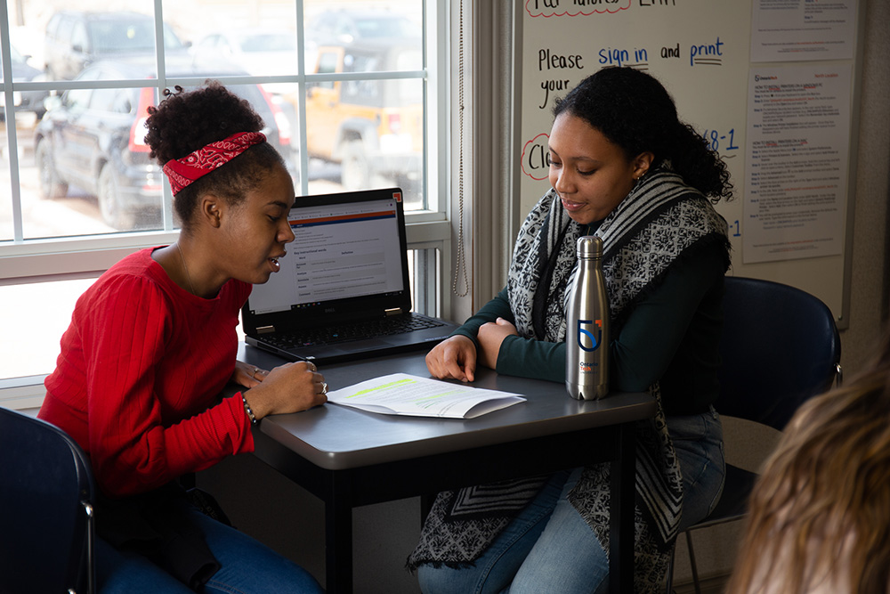 image of Ontario Tech senior student tutoring a younger student in an office space