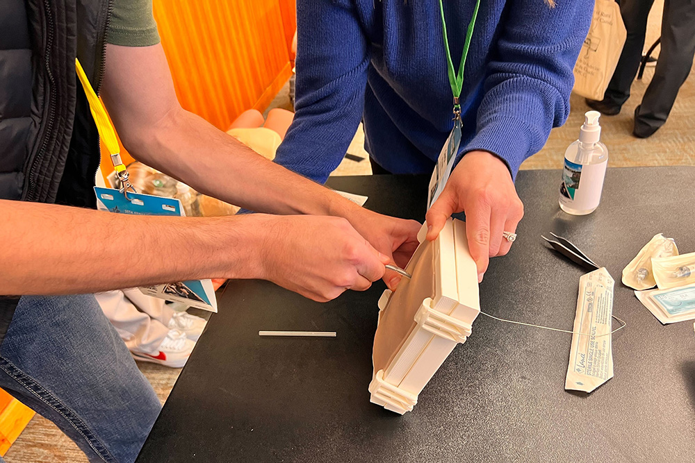 Image of a chest (thoracostomy) tube insertion depicting a doctor practising where to insert the needle. A thoracostomy tube, is a flexible tube that must be inserted through the chest wall between the ribs into the pleural space. Once the opening is made, fluids or air is allowed to escape and the collapsed lung ‘reinflates’. If inserted in the wrong place, it enters nerves and vessels. If too deep, it may damage the lung, and if not deep enough, it won't work. 