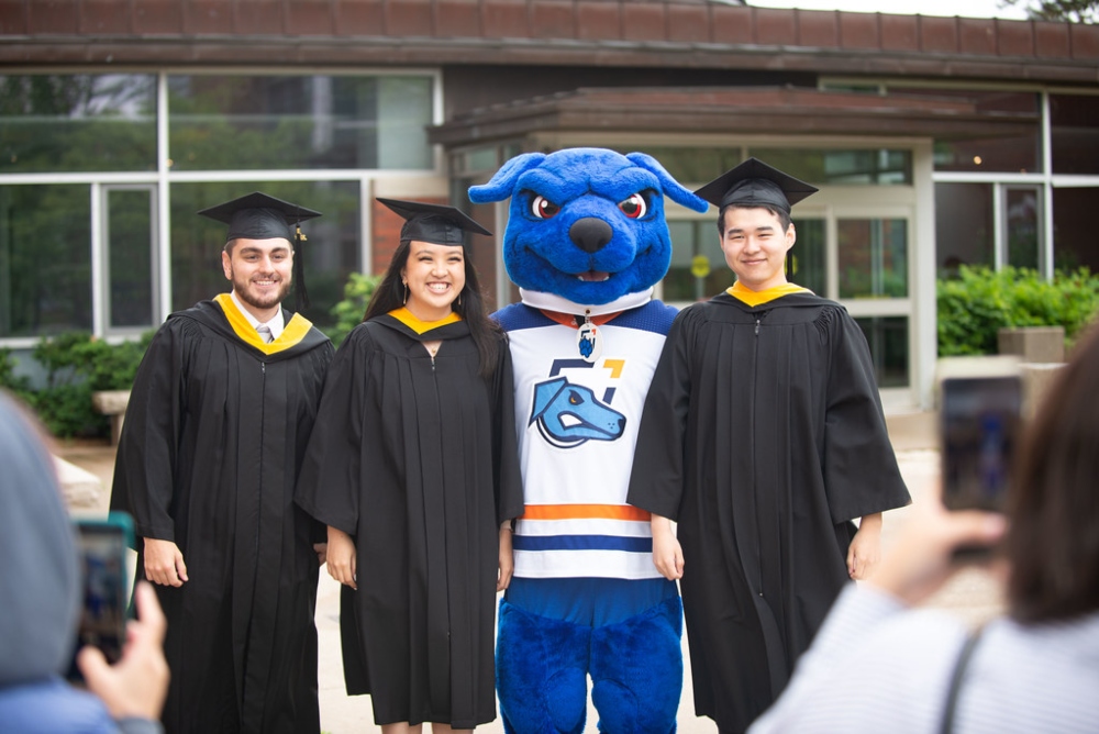 Graduating students with Hunter the Ridgeback at Convocation on Polonsky Commons