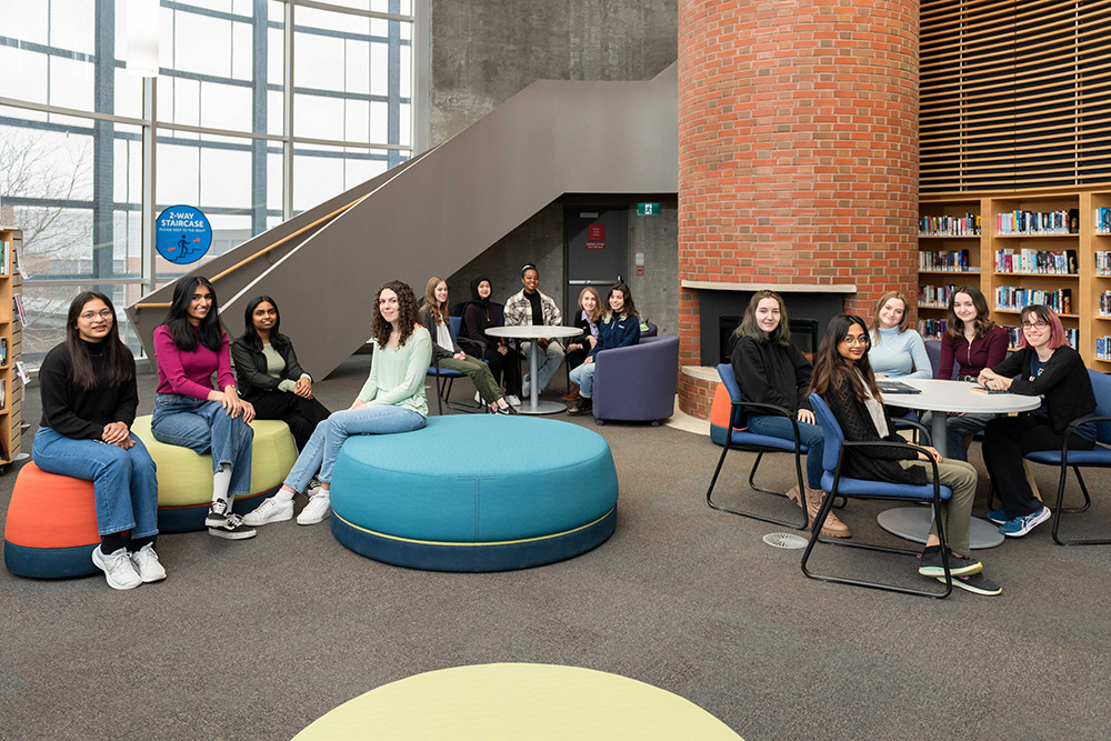Ontario Tech Women for STEM program students gather in the Dixon/Alger Fireside Reading Room in the Campus Library at the university's north Oshawa location (March 2023).