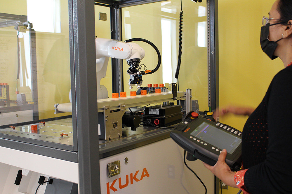Megha Verma, Lab Specialist, Faculty of  Engineering and Applied Science uses the teach-pendant to operate the new robot arms in the Robotics and Automation Lab.