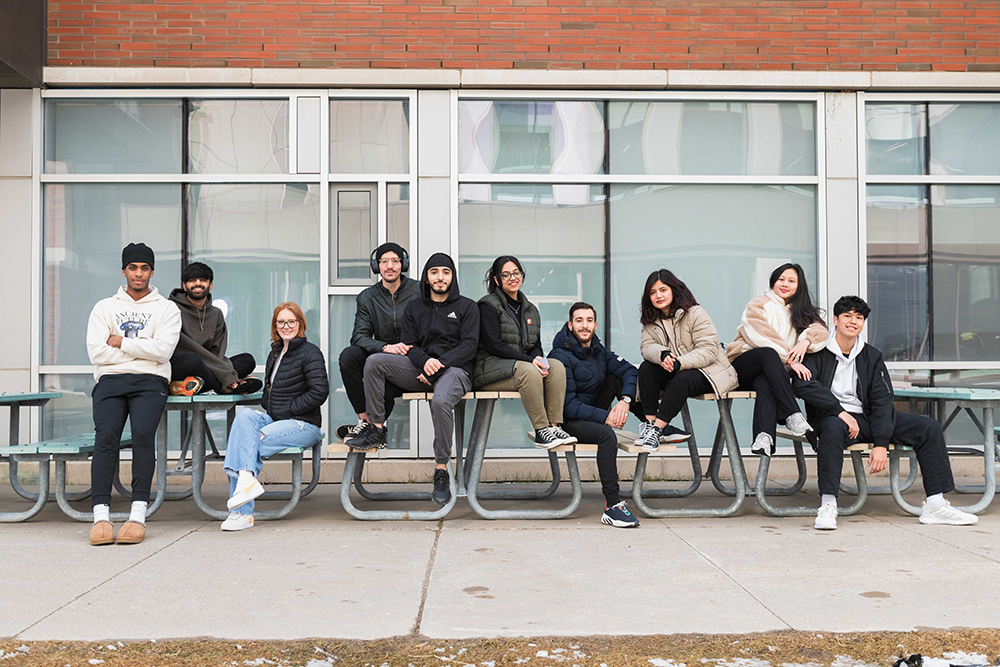 image of Ontario Tech students outside Shawenjigewining Hall at the university's north Oshawa location.