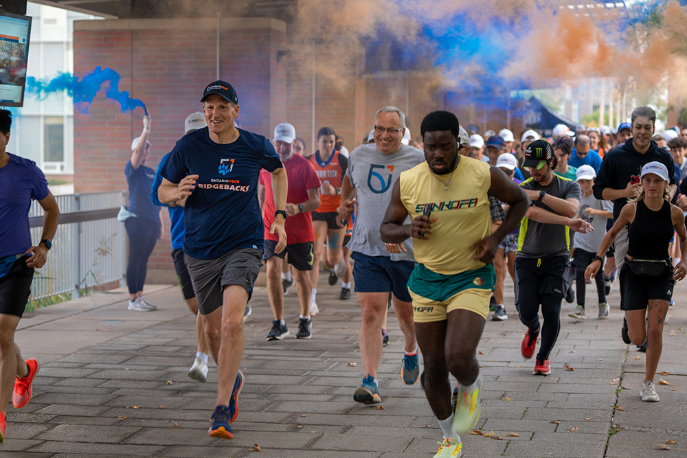 Chancellor Mitch Frazer (left, navy blue shirt) and President Steven Murphy (grey shirt), lead more than 400 participants at the 2024 Ontario Tech Chancellor's Challenge at Polonsky Commons (September 21, 2024).