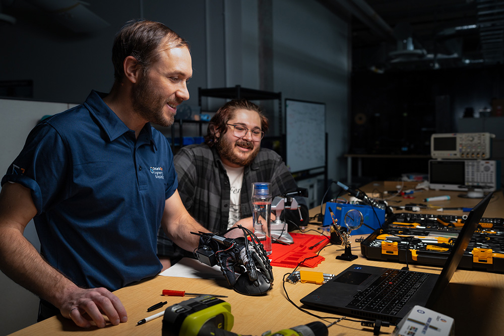 Dr. Aaron Yurkewich working on the HERO Glove with FEAS master's degree student Daimen Landon-Hoffman in the Ontario Tech University BioRobotics Lab.