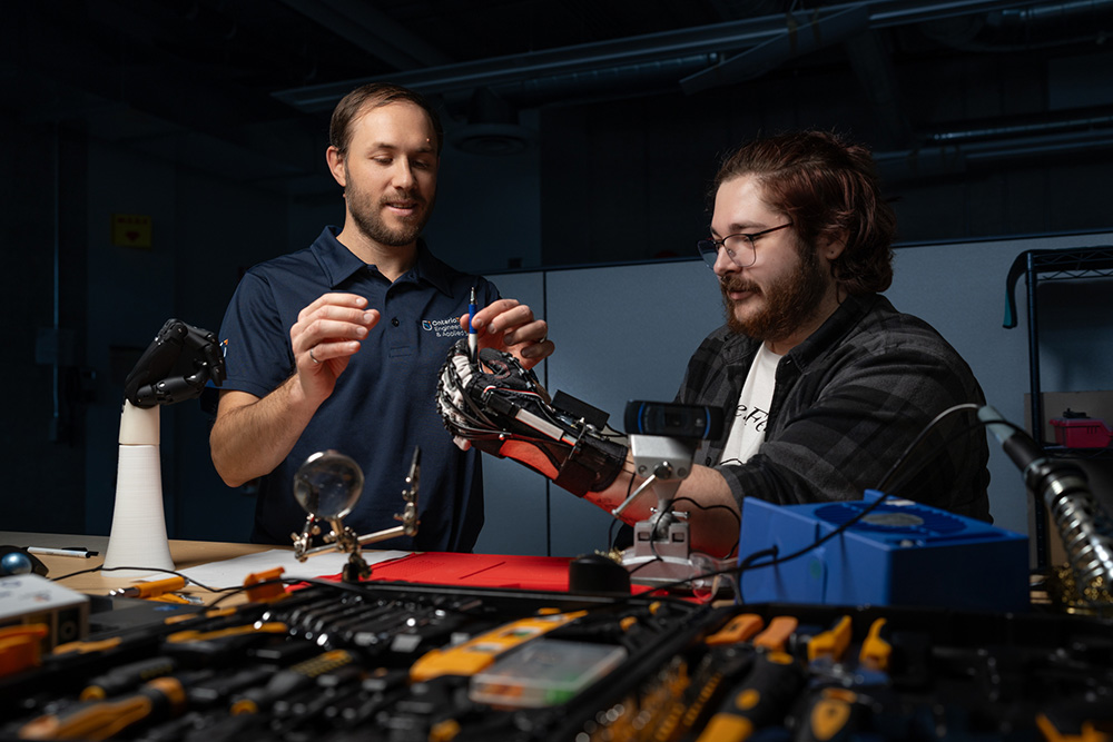 Dr. Aaron Yurkewich (left), Assistant Professor, Faculty of Engineering and Applied Science (FEAS) working on the HERO Glove with FEAS master's degree student Daimen Landon-Hoffman (Ontario Tech University BioRobotics Lab, January 27, 2025).  