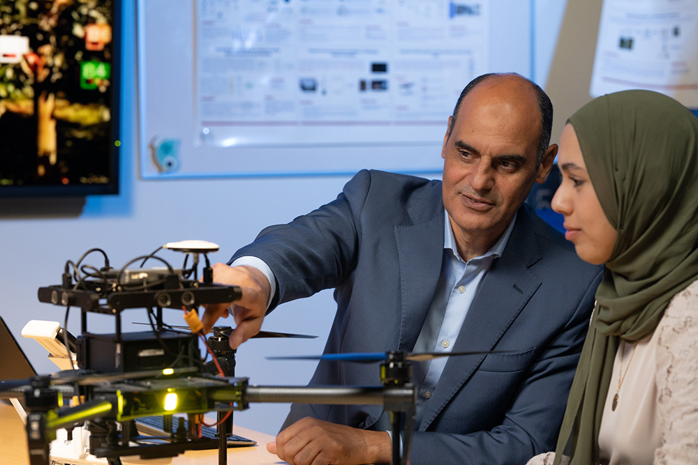 Dr. Khalid Elgazzar, Canada Research Chair in the Internet of Things (IoT) at Ontario Tech University (left), speaks with a member of his research group in the IoT Research Lab.