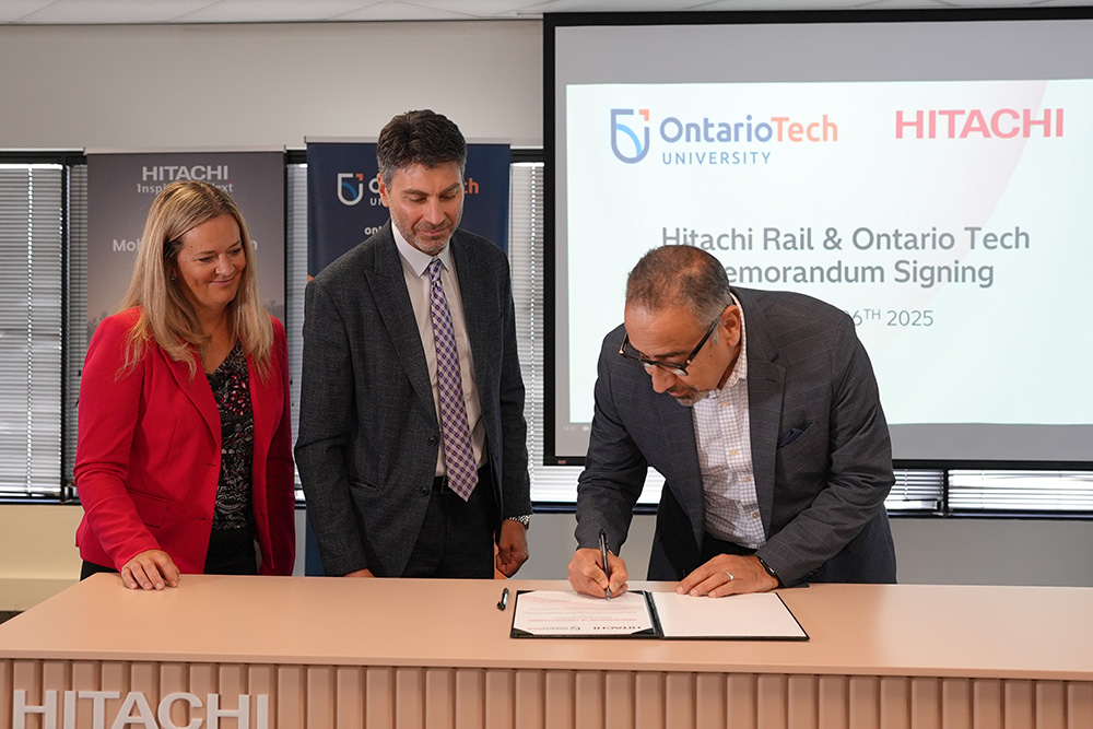 Dr. Hossam Kishawy, Dean, Faculty of Engineering and Applied Science, Ontario Tech University (right) signs Memorandum of Understanding with Hitachi Rail at ceremony in Toronto, Ontario. With Kathryn Deline, Vice President, Human Resources, Hitachi Rail (left) and Ziad Rizk, Managing Director, Hitachi Rail Canada centre). (August 26, 2015)