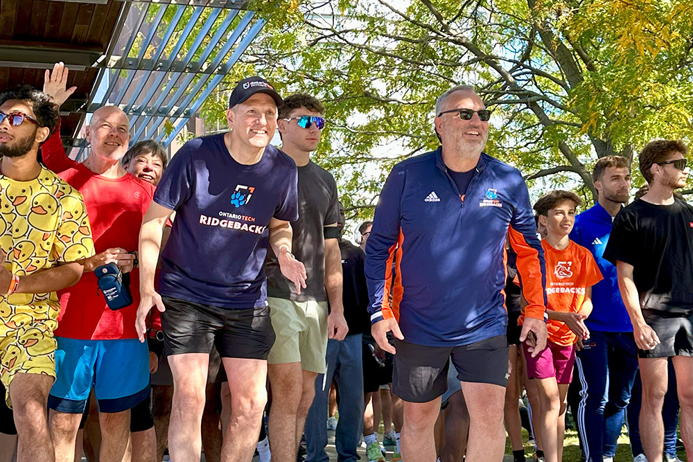 Chancellor Mitch Frazer (centre-left, navy blue T-shirt) and President Steven Murphy (centre-right, blue and orange long-sleeve), lead more than 700 participants at the 2025 Ontario Tech Chancellor's Challenge at Polonsky Commons (September 20, 2025).
