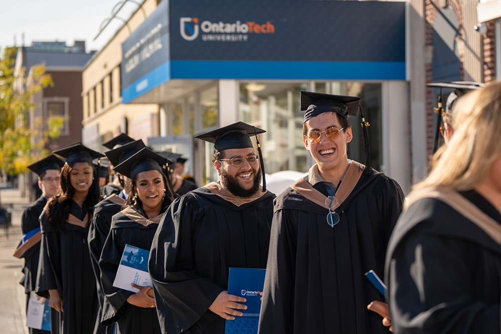 Graduates celebrating at Ontario Tech's 2023 Fall Convocation, outside the university's Regent Theatre in downtown Oshawa.