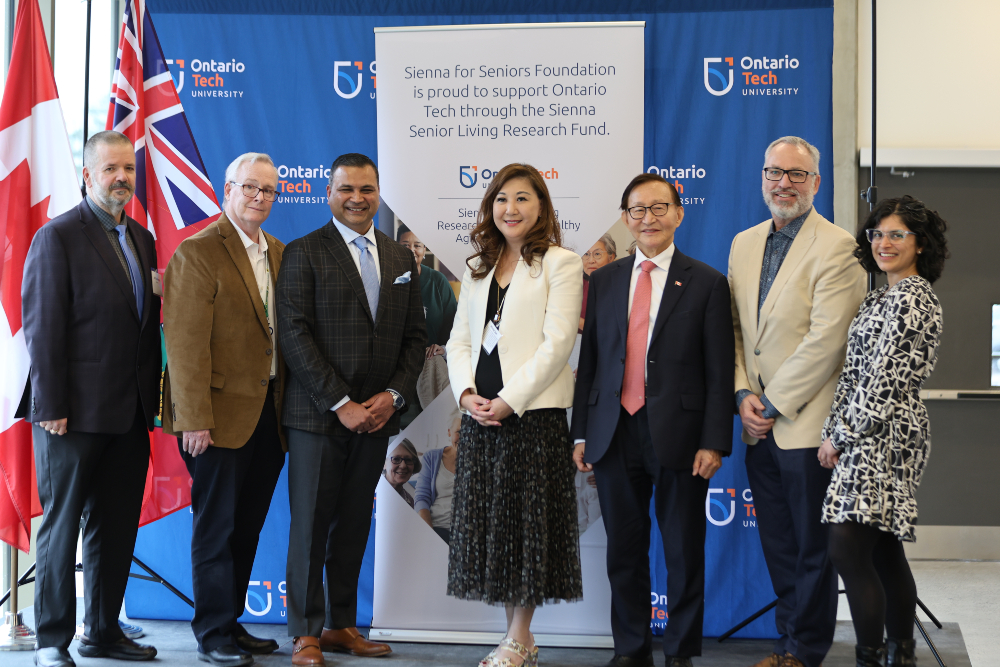 From left: Attila Kovacs, graduate student, Faculty of Health Sciences and previous recipient of the Sienna Senior Living Nursing Scholarship; John Henry, Regional Chair and CEO, The Regional Municipality of Durham; Nitin Jain, President and CEO, Sienna Senior Living; Dr. Winnie Sun, Research Excellence Chair in Healthy Aging and Dementia Care, Co-Research Director, Advancement in Dementia Care Centre, Ontario Shores Centre for Mental Health Sciences, Scientific Director, Wellness Innovations in NeuroAging Research Hub, and Associate Professor, Faculty of Health Sciences (FHSc), Ontario Tech University; The Honourable Raymond Cho, Ontario’s Minister for Seniors and Accessibility; Dr. Steven Murphy, President and Vice-Chancellor, Ontario Tech; and Dr. Shilpa Dogra, Director, Active Living and Longevity Lab, Founding Chair, Age-Friendly University Initiative and Professor, FHSc and Research Excellence Chair in Disrupting Human Mobility, Ontario Tech.