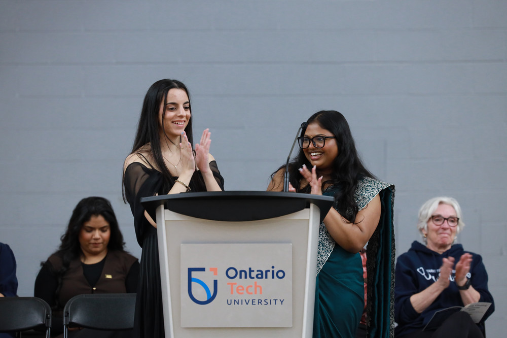 Students standing at Ontario Tech University podium 