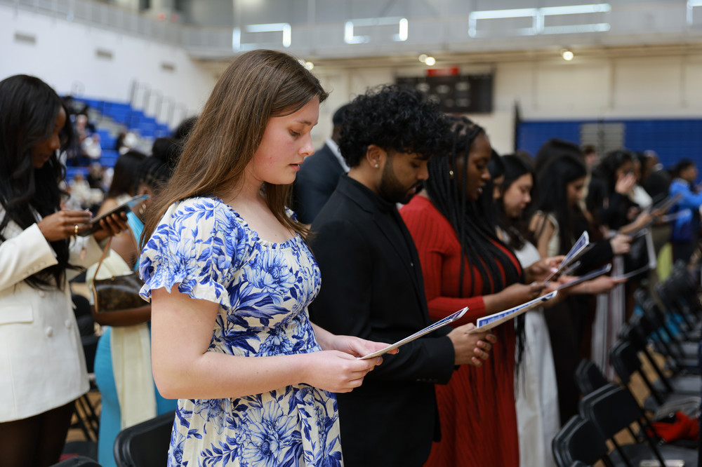 Students standing in the gym reciting the Nurses Pledge 